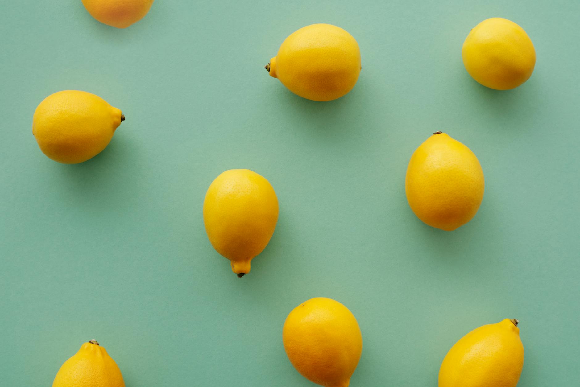 Bright yellow lemons on a pastel green background, representing the Lemon clitoral vibrator