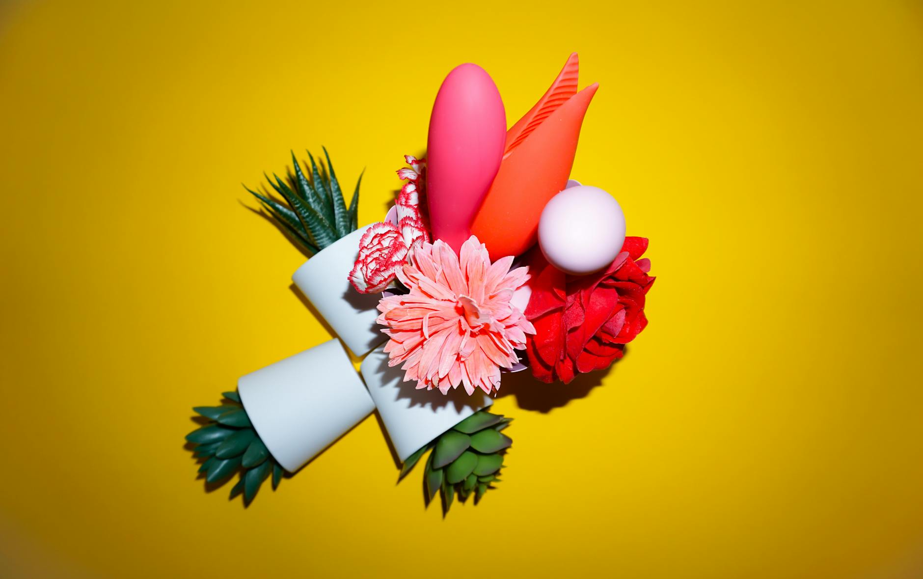 Colorful arrangement of vibrators and wellness objects on a bright background